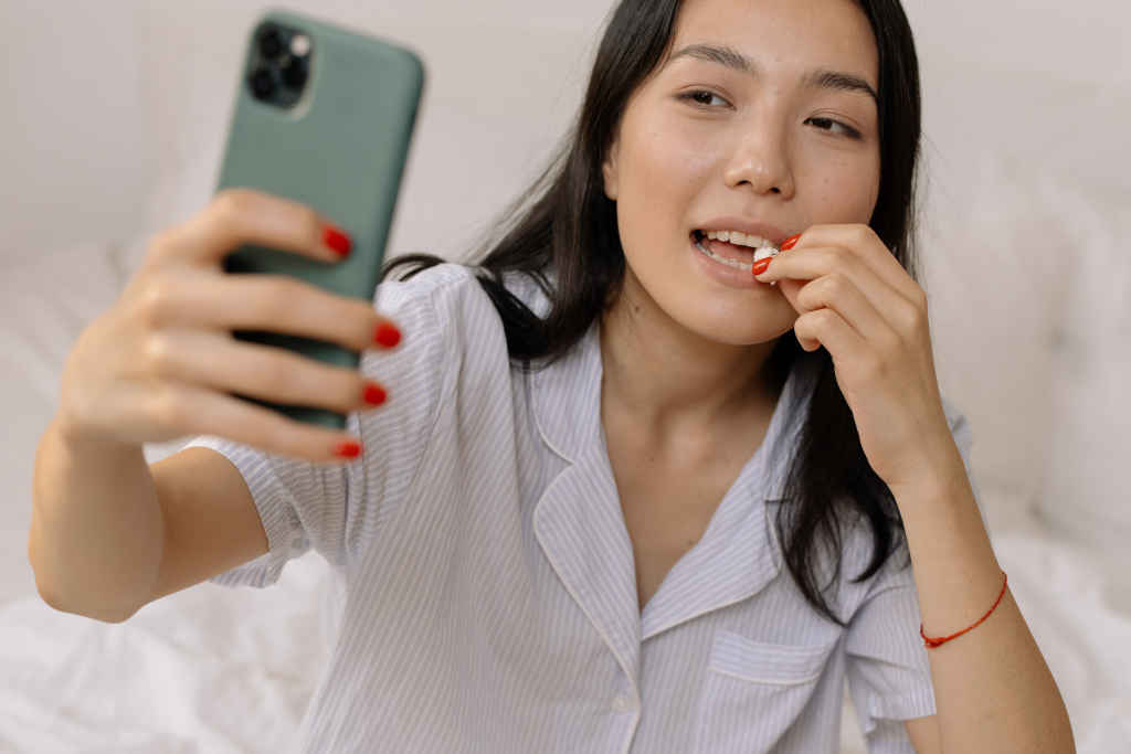 Woman in white dress taking a selfie - Photo by cottonbro on pexels