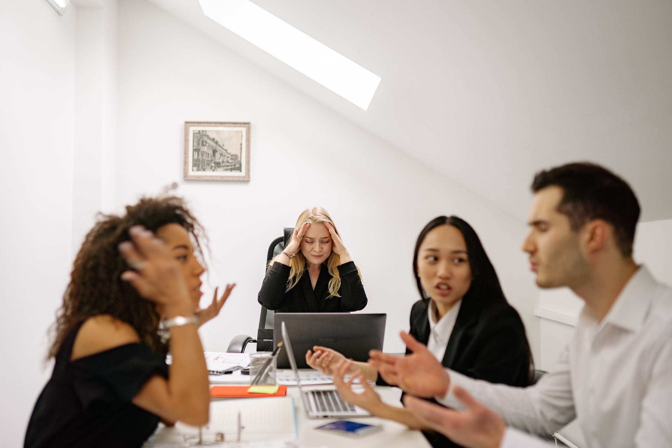 Two employees at work arguing and causing headache for another